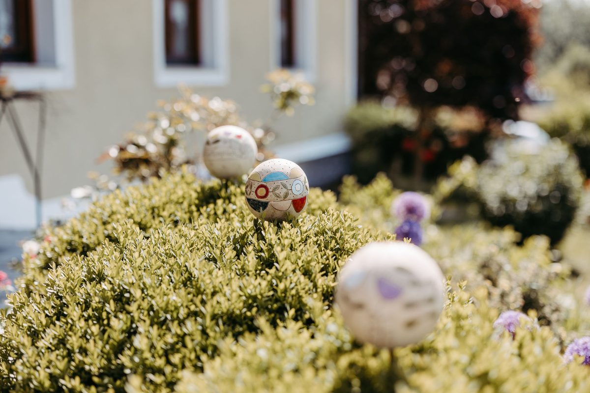 Bunte Keramikkugel zwischen Blumen